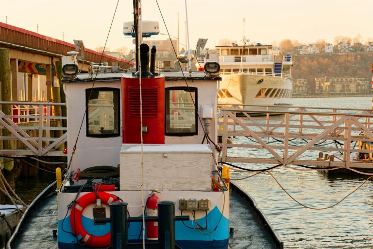 Fishing boat docked at a tranquil New York harbor during sunset, capturing vibrant reflections.